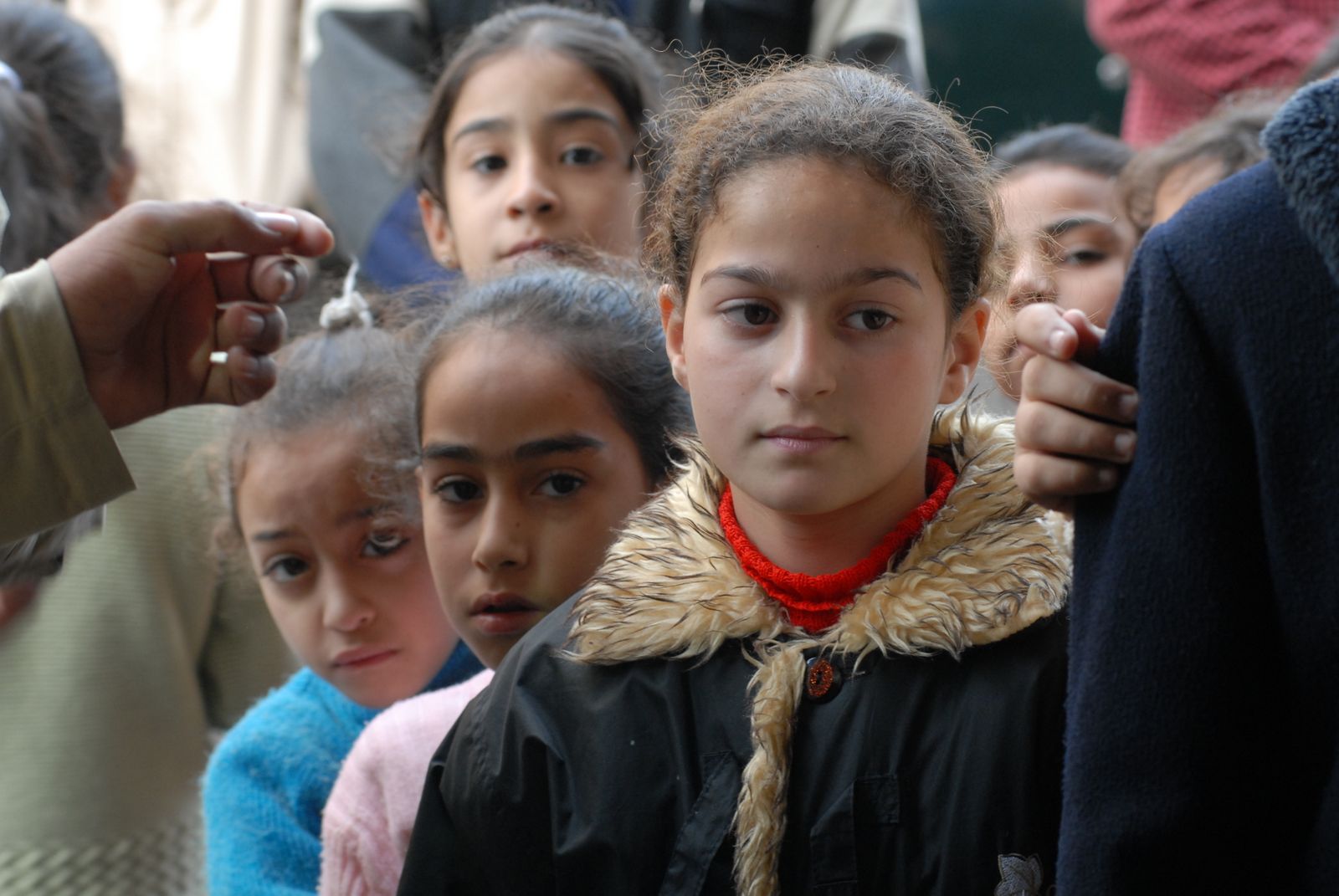 Alcune bambine e bambini in fila per un pezzo di pane. La guerra a Gaza è anche questo