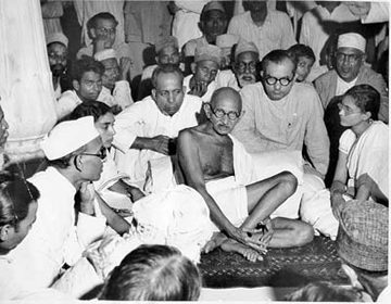 Un politico dunque, o un santo? In questa foto Gandhi ascolta alcuni musulmani durante il momento culminante delle sanguinose lotte che seguirono la partizione dell'India, nel 1947.
