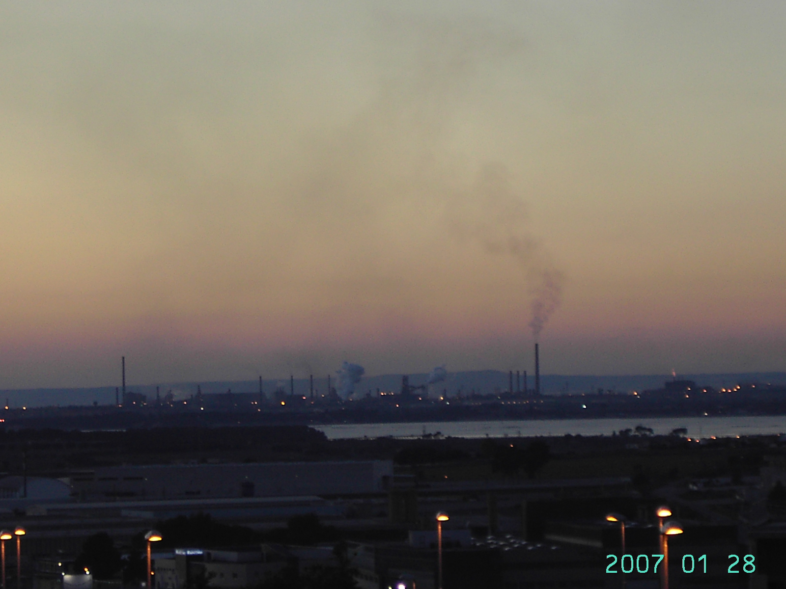 Tramonto a Taranto con diossina. Ogni settimana Nichi Vendola riceve foto come queste da attivisti ambientali come Giulio Farella. Il camino più alto a destra da cui esce fumo è considerato fonte di emissione per il 90% del totale della diossina industria